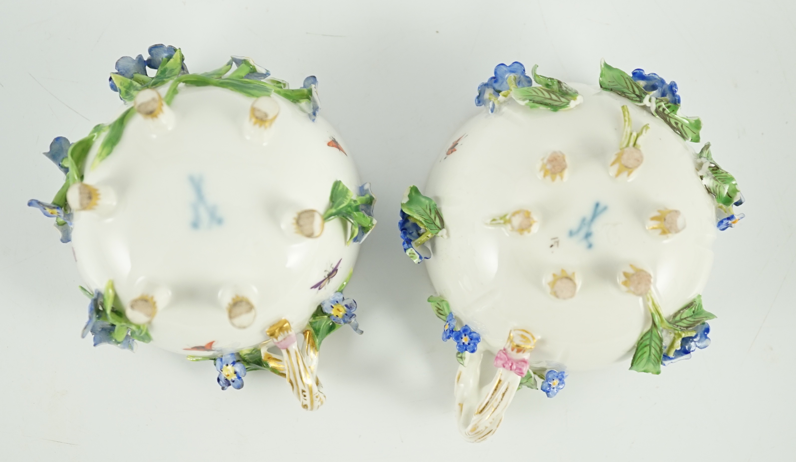 Two Meissen flower encrusted cups and saucers, 19th century, saucers 12cm wide, chips to flowers and leaves